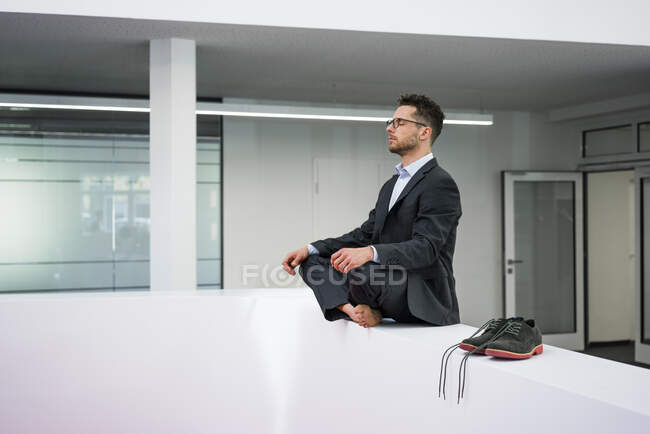 Uomo d'affari che fa yoga in ufficio — Foto stock