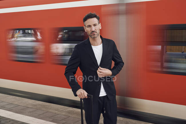 Mature man with trolley on station — Stock Photo