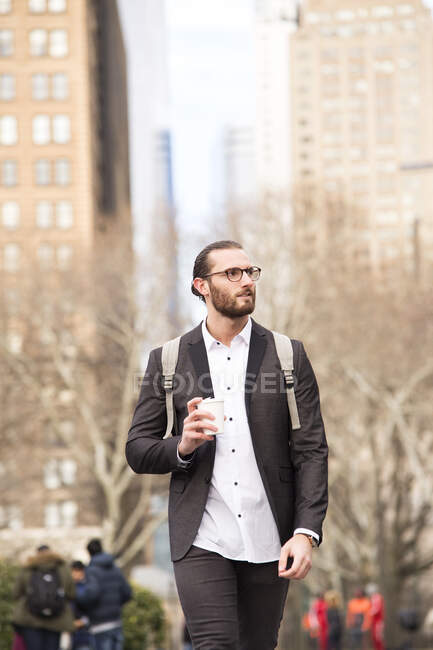 Retrato de un joven hombre de negocios barbudo con mochila y café para  llevar, Nueva York, . — Caucásica, aire libre - Stock Photo |  #462885456