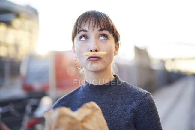 Porträt einer jungen Frau mit Pommes-Schnurrbart und schmollendem Mund — Stockfoto