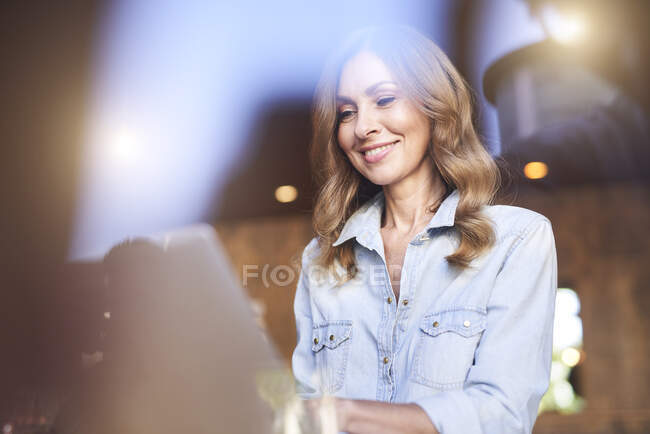 Mujer de negocios usando portátil en una cafetería - foto de stock