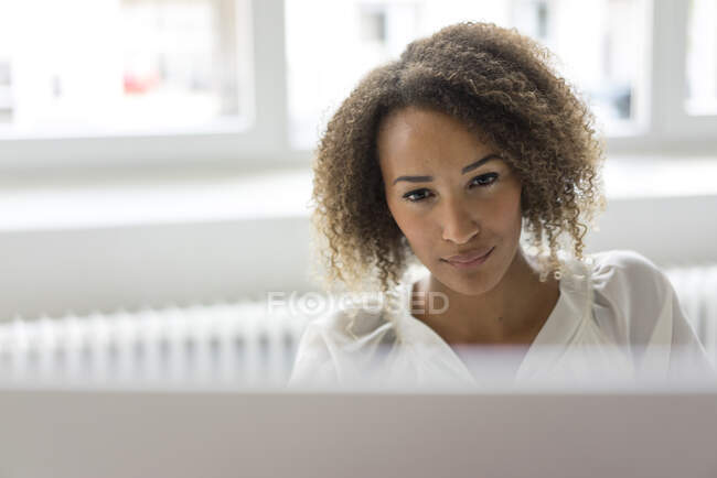 Portrait of smiling young freelancer working at desk — Stock Photo