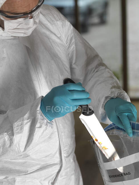 Forensic scientist bagging a knife taken from a violent crime scene — Stock Photo