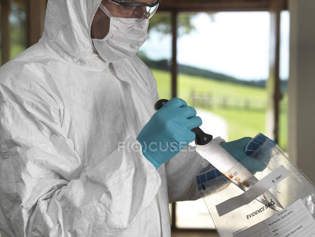 Forensic scientist bagging a knife taken from a violent crime scene — Stock Photo