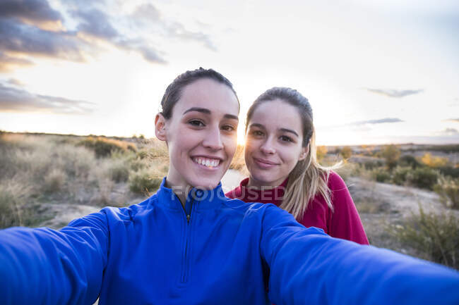 Young women in sportswear taking selfie with smartphone — Stock Photo