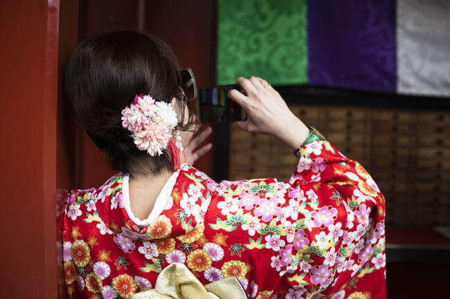 Mujer japonesa con ropa tradicional japonesa tomando una foto en Tokio, Japón - foto de stock