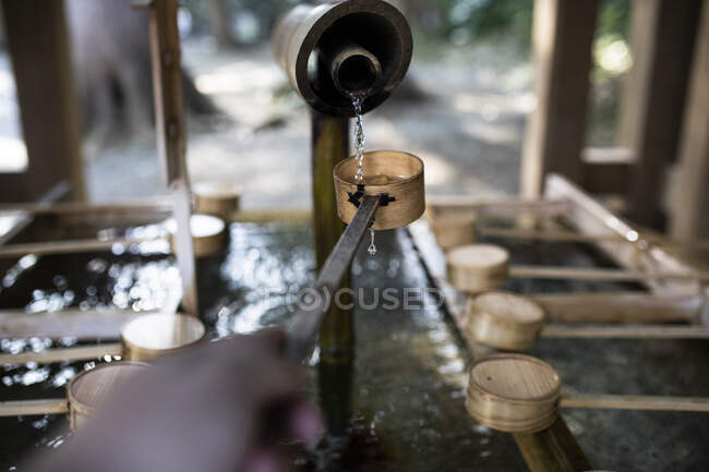 Jovem mulher pegando água para o ritual de lavar as mãos em um templo de Tóquio, Japão — Fotografia de Stock