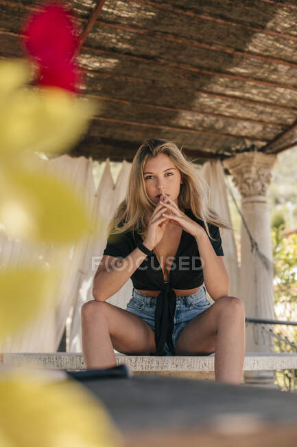 Retrato de una hermosa joven sentada en una mesa al aire libre - foto de stock