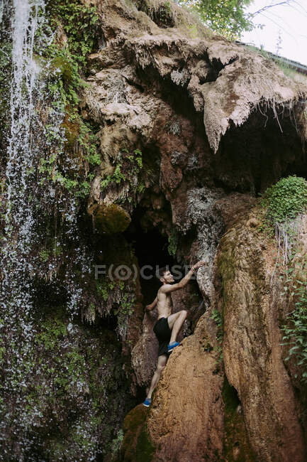 Giovanotto scalato a malapena su una cascata — Foto stock
