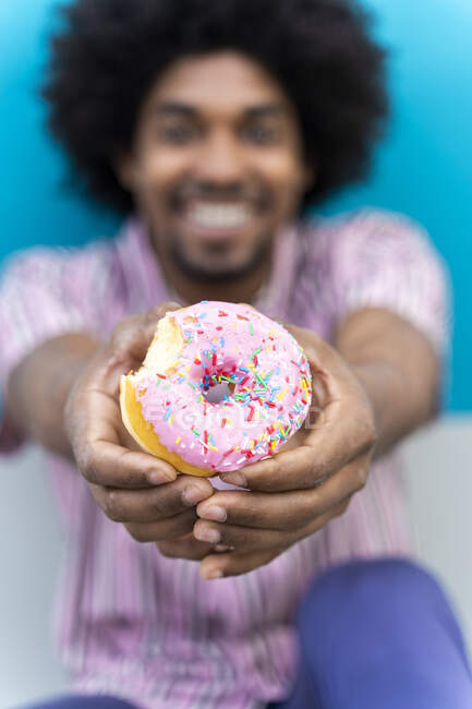 Junger Mann isst Donut — Stockfoto
