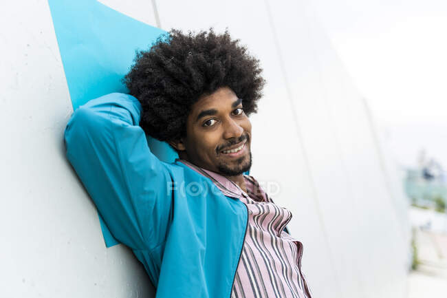 Retrato de un joven apoyado en una pared blanca - foto de stock