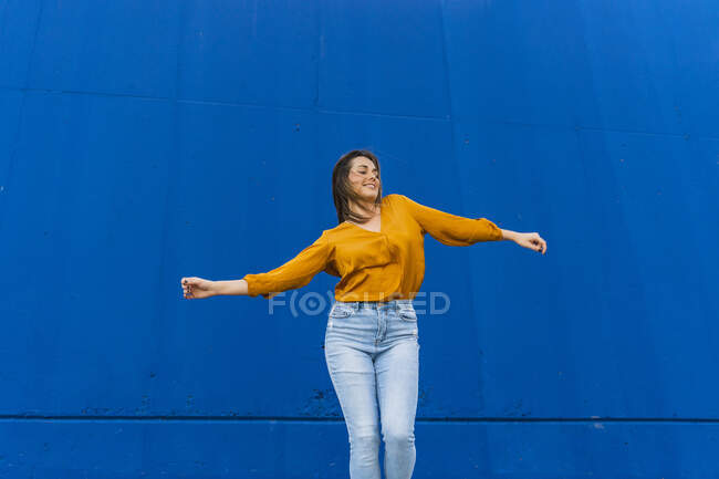 Молодая танцовщица перед синей стеной — стоковое фото