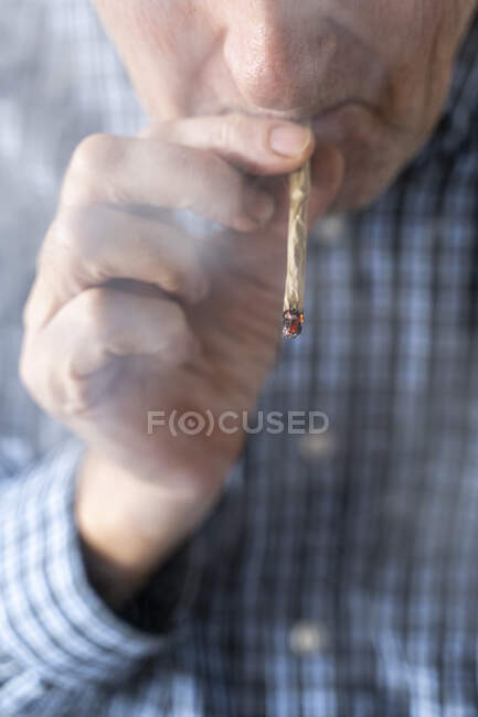 Старший чоловік удома курить марихуану. — стокове фото