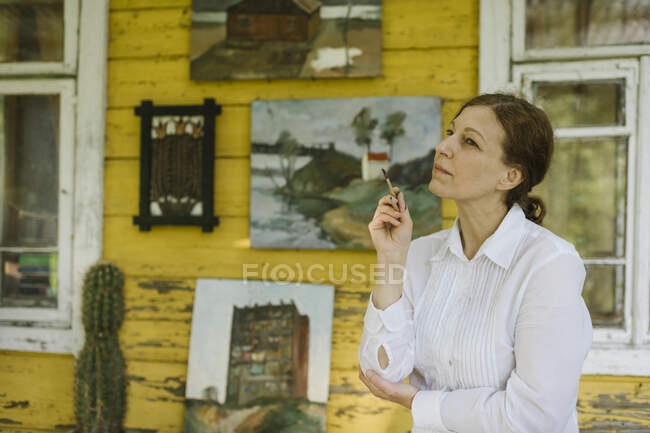 Pittore donna al vecchio villaggio di legno casa terrazza — Foto stock