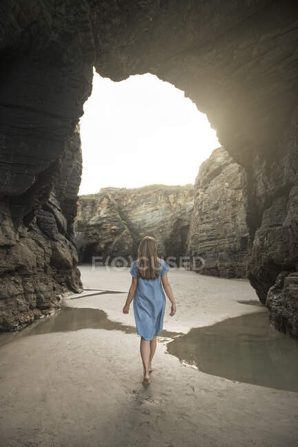Donna che cammina sulle cattedrali Spiaggia con scogli, vista posteriore, Galizia, Spagna — Foto stock