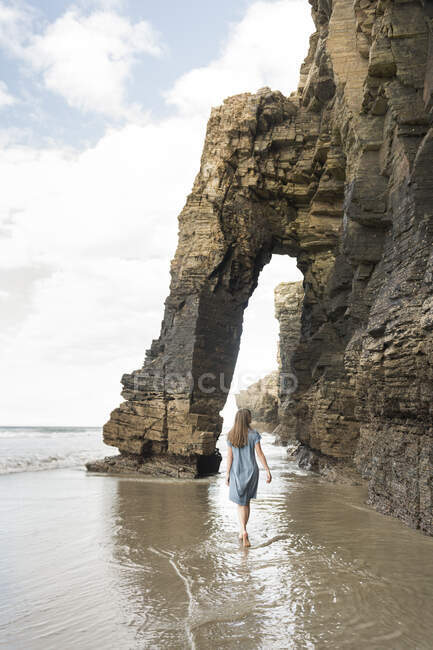 Donna che cammina sulle cattedrali Spiaggia con scogli, vista posteriore, Galizia, Spagna — Foto stock