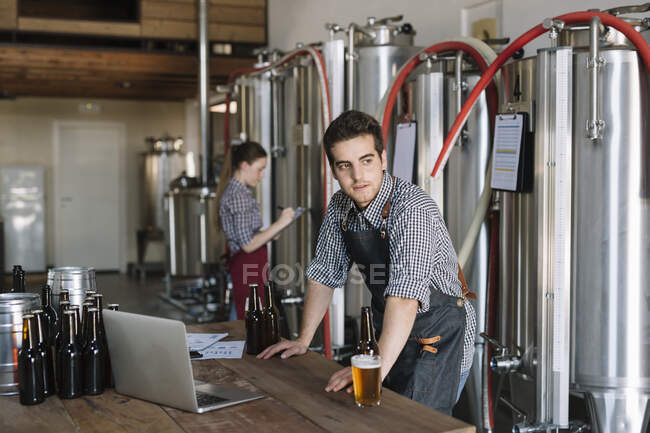 Jungunternehmer arbeiten mit Laptop in einer Brauerei — Stockfoto
