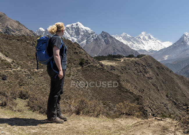 Mujer mirando a Ama Dablam y el Monte Everest, Himalaya, Solo Khumbu, Nepal - foto de stock