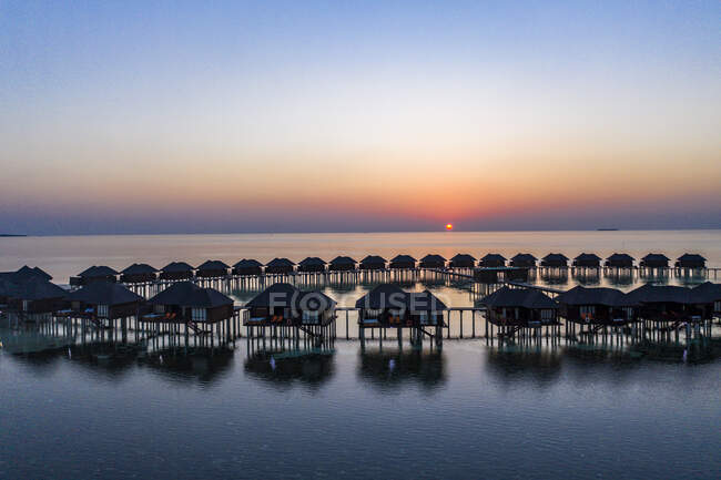 Maldives, Olhuveli island, Resort bungalows on South Male Atoll lagoon at sunset — Stock Photo