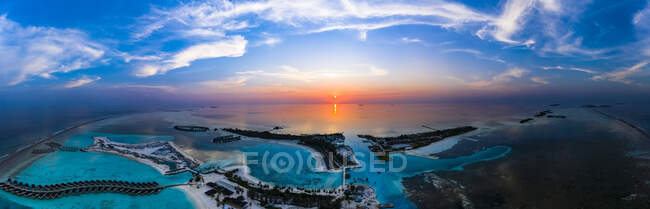 Maldivas, Isla Olhuveli, Vista aérea del complejo en la laguna del atolón sur al atardecer - foto de stock