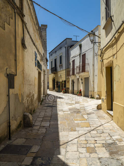Пустой переулок среди зданий в старом городе в солнечный день — стоковое фото