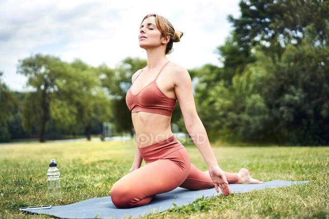 Woman practicing yoga in park — Stock Photo