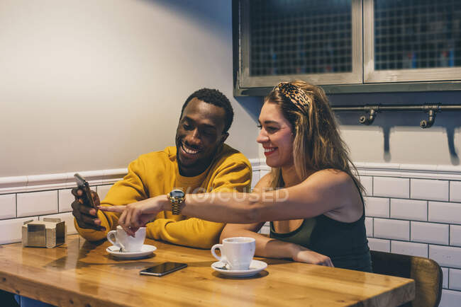 Porträt eines lächelnden Paares in einem Coffeeshop per Smartphone — Stockfoto