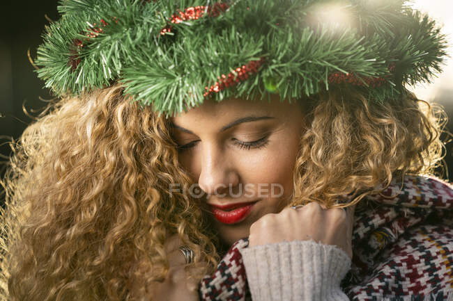 Портрет усміхненої молодої жінки з різдвяним вінком на голові. — стокове фото