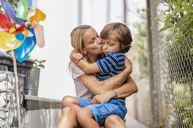 Madre snd figlio abbracciare e baciare in giardino — Foto stock