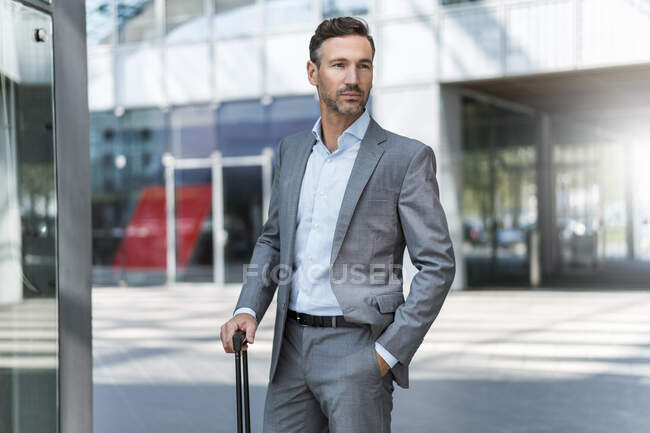 Portrait of confident businessman with baggage — Stock Photo