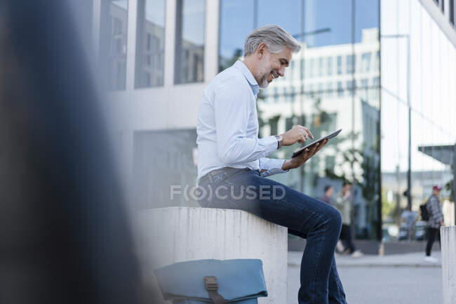 Sourire homme d'affaires mature en utilisant une tablette dans la ville — Photo de stock