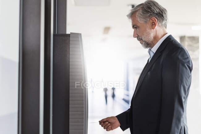 Businessman withdrawing money at an ATM — Stock Photo