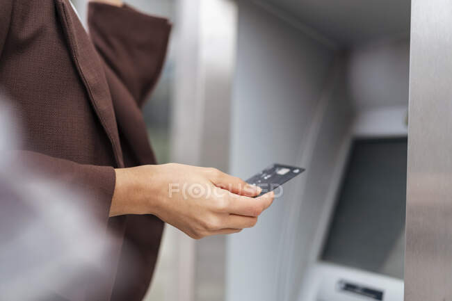 Gros plan d'une femme d'affaires qui retire de l'argent à un guichet automatique — Photo de stock