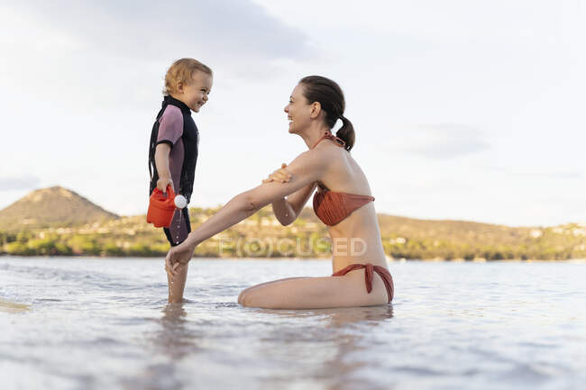 Щаслива мати і дочка грають з лійкою в морі — стокове фото
