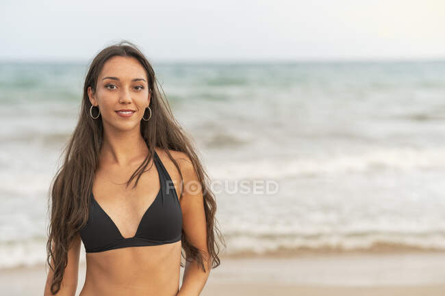 Retrato de una hermosa joven en bikini en la playa - foto de stock