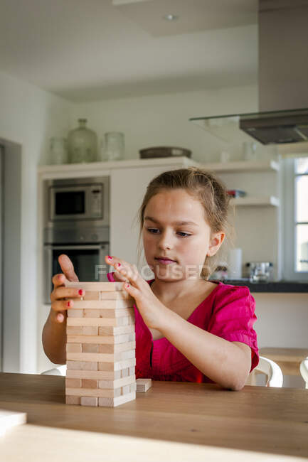 Retrato de menina jogando na mesa em casa — Fotografia de Stock