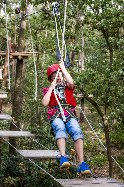 Girl on a high rope course in forest — Stock Photo