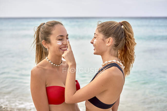 Deux jeunes femmes s'amusent sur une plage — Photo de stock