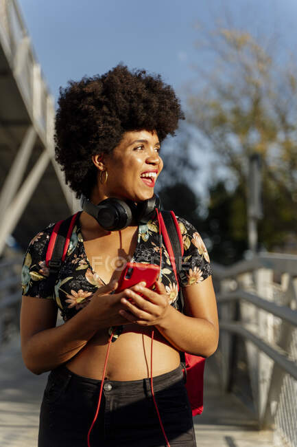 Afroamerikanerin mit Kopfhörern und Smartphone beim Musikhören — Stockfoto