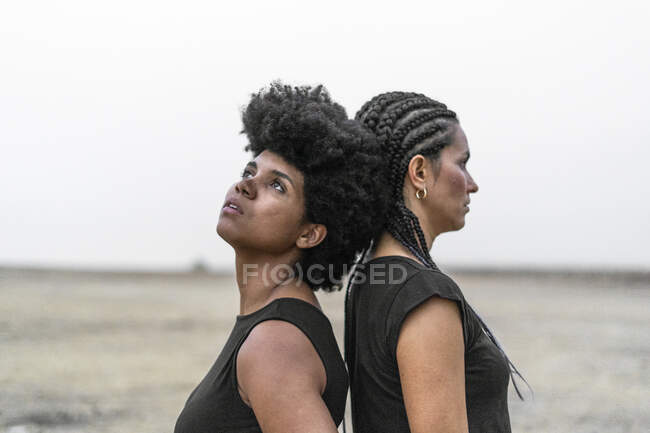 Due donne schiena a schiena in un paesaggio desolato — Foto stock