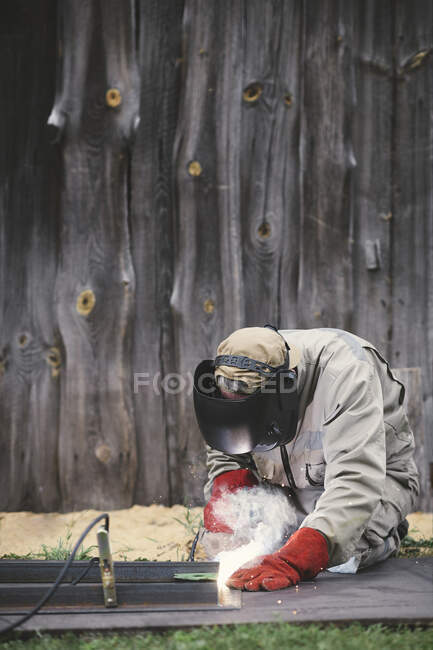 Man welding metal in his backyard — Stock Photo