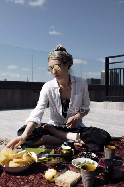 Donna elegante con occhiali da sole che fanno un pasto sano sul tetto — Foto stock