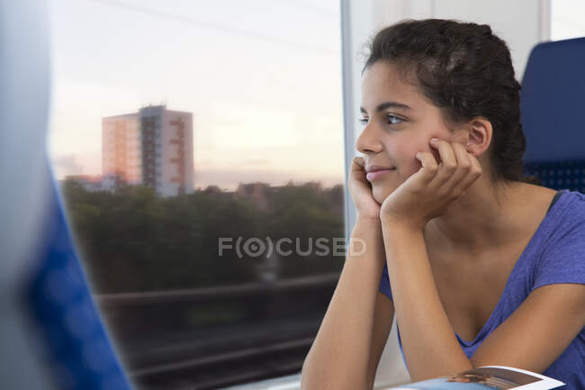 Adolescente viajando sozinha de trem, olhando pela janela — Fotografia de Stock