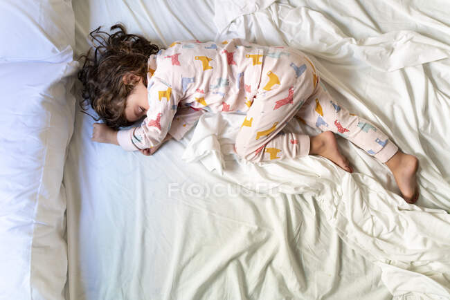 Vista superior de la linda niña durmiendo en la cama - foto de stock