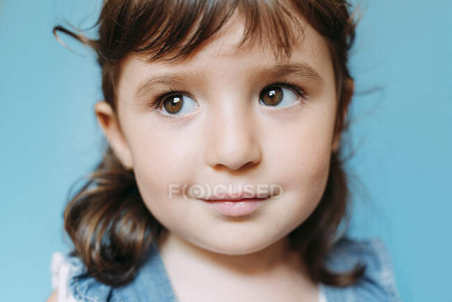 Ritratto di bambina carina, sfondo blu — Foto stock