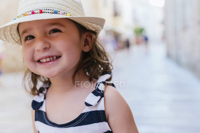 Портрет смеющейся маленькой девочки в соломенной шляпе — стоковое фото