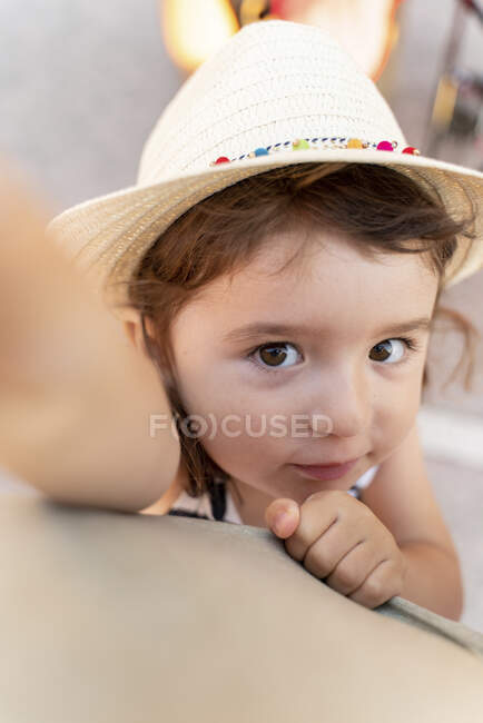 Retrato de niña con cabello castaño y ojos con sombrero de paja - foto de stock