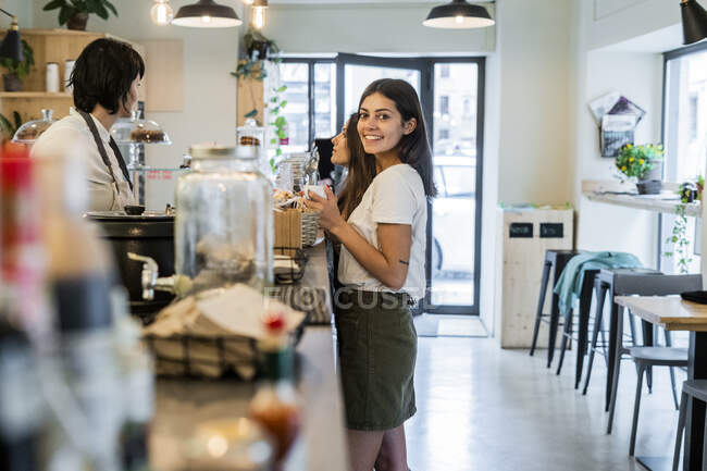 Дві щасливі молоді друзі на стійці в кафе — стокове фото