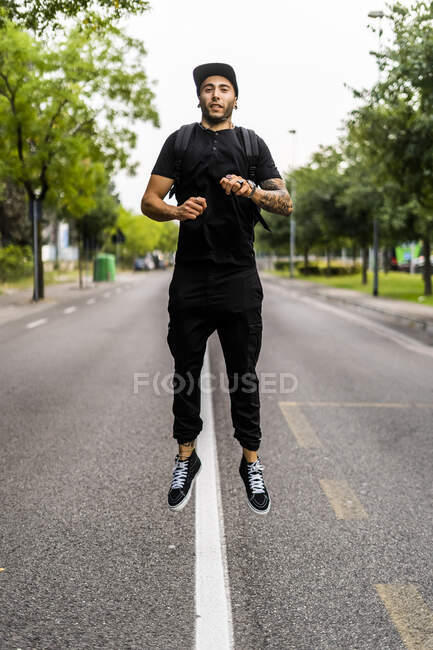 Молодой человек, прыгающий в воздух на улице — стоковое фото