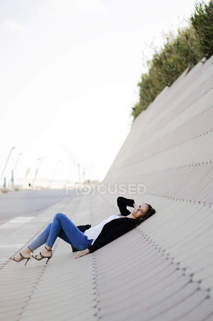Femme d'affaires se détendre à l'extérieur couché sur des dalles — Photo de stock